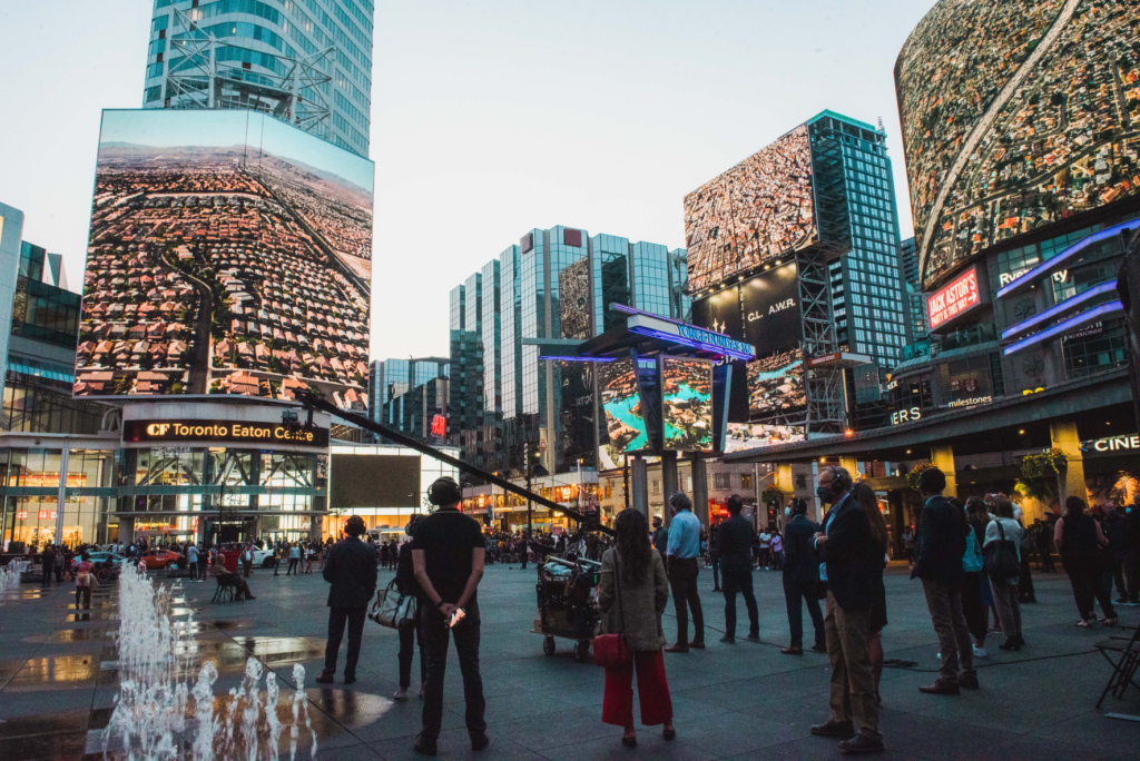 Photo of Yonge Dundas Square in Toronto with Edward Burtynsky's photography filling the screens in the square