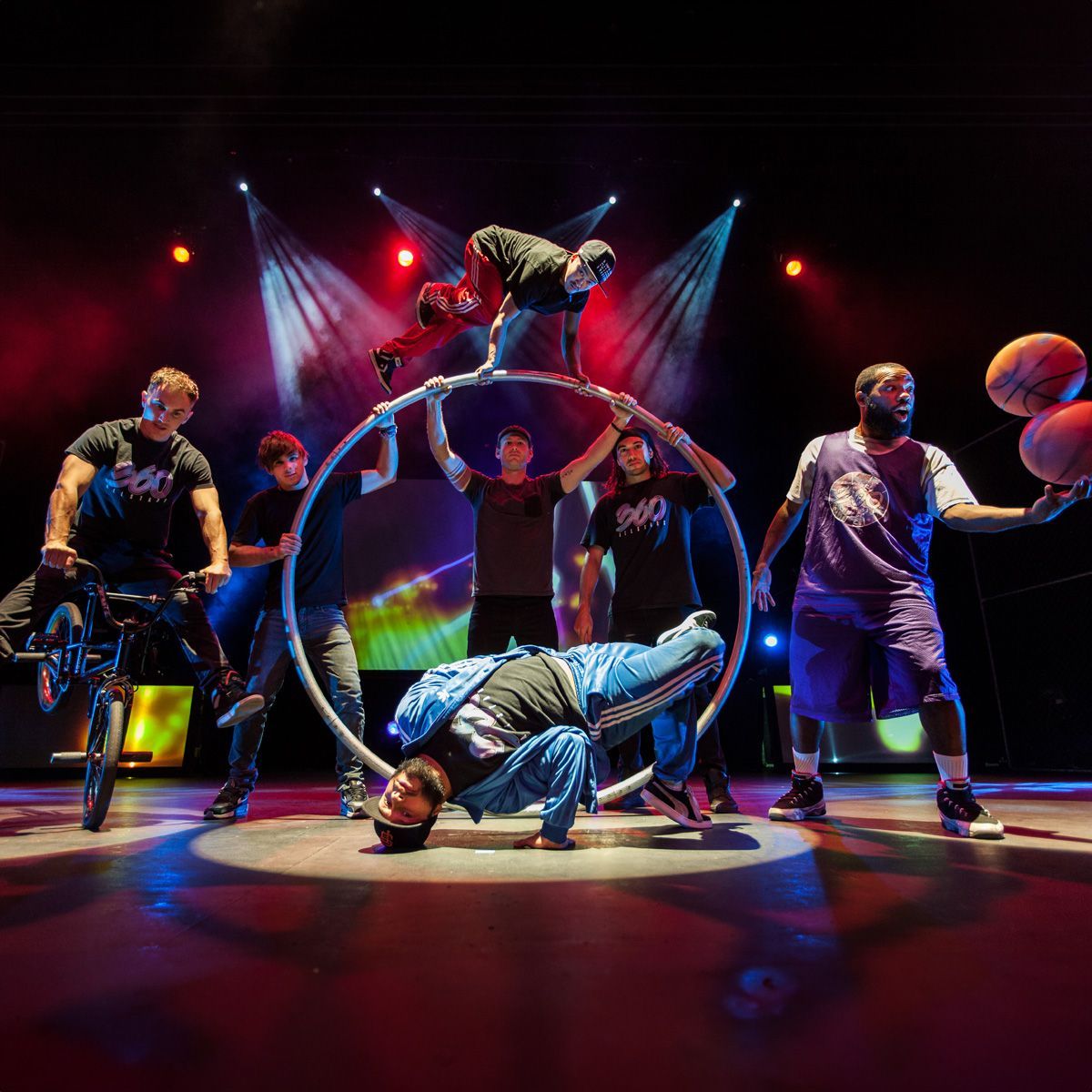 A group of people are performing on a stage and one of them is holding a basketball