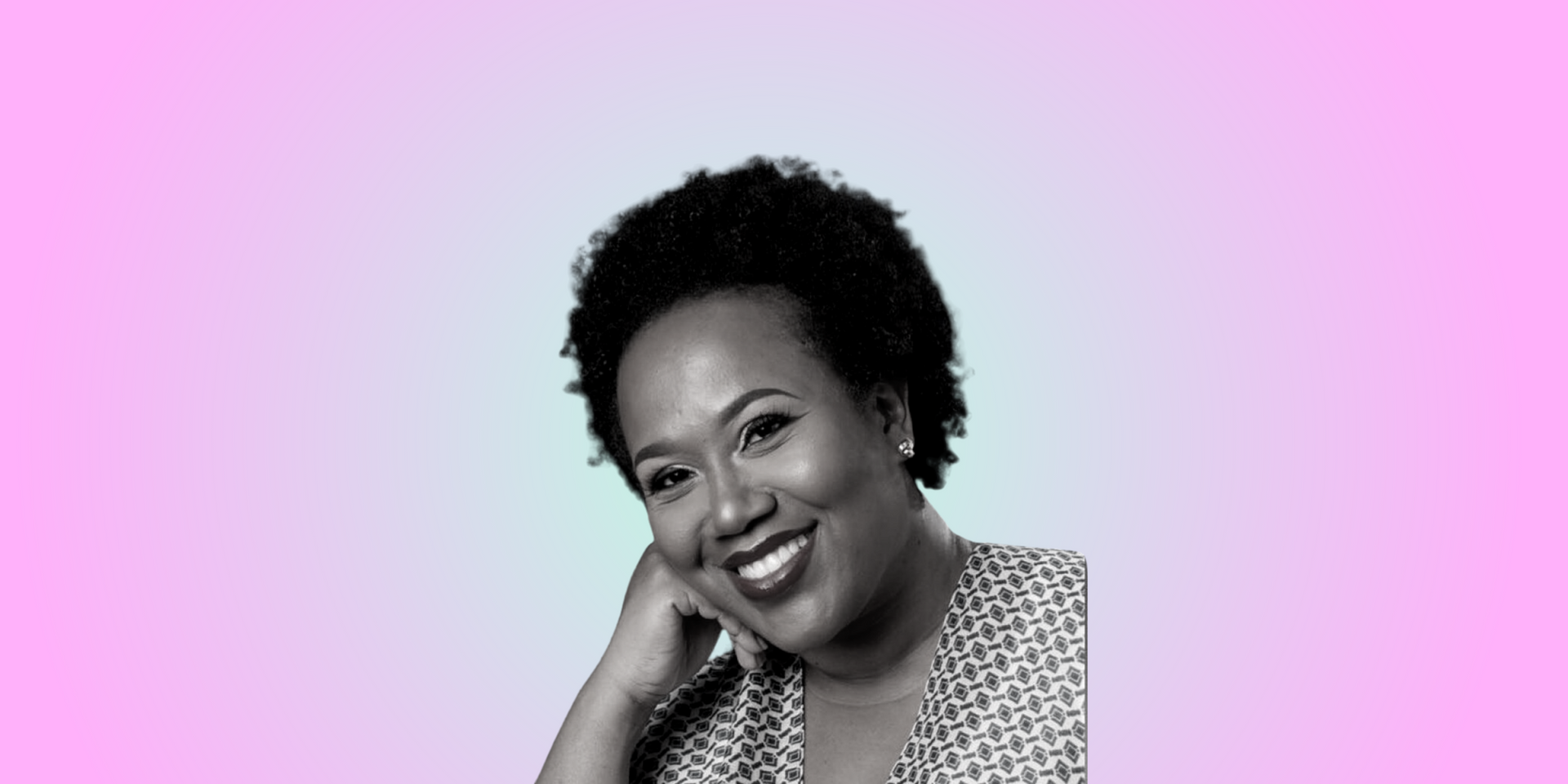 A black and white photo of a woman smiling with her hand on her chin.