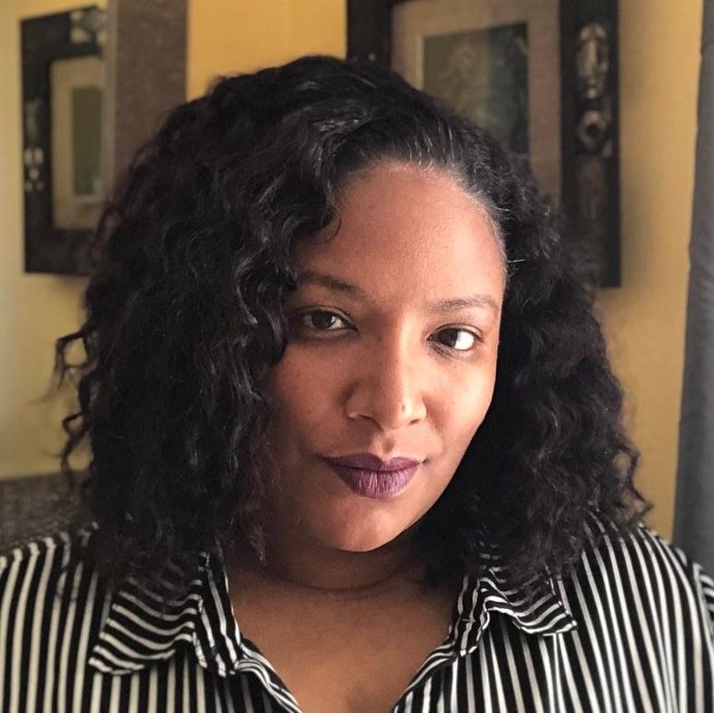 A woman with curly hair wearing a black and white striped shirt