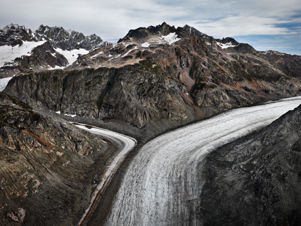 An image of a mountain valley with a clear blue sky behind it. 