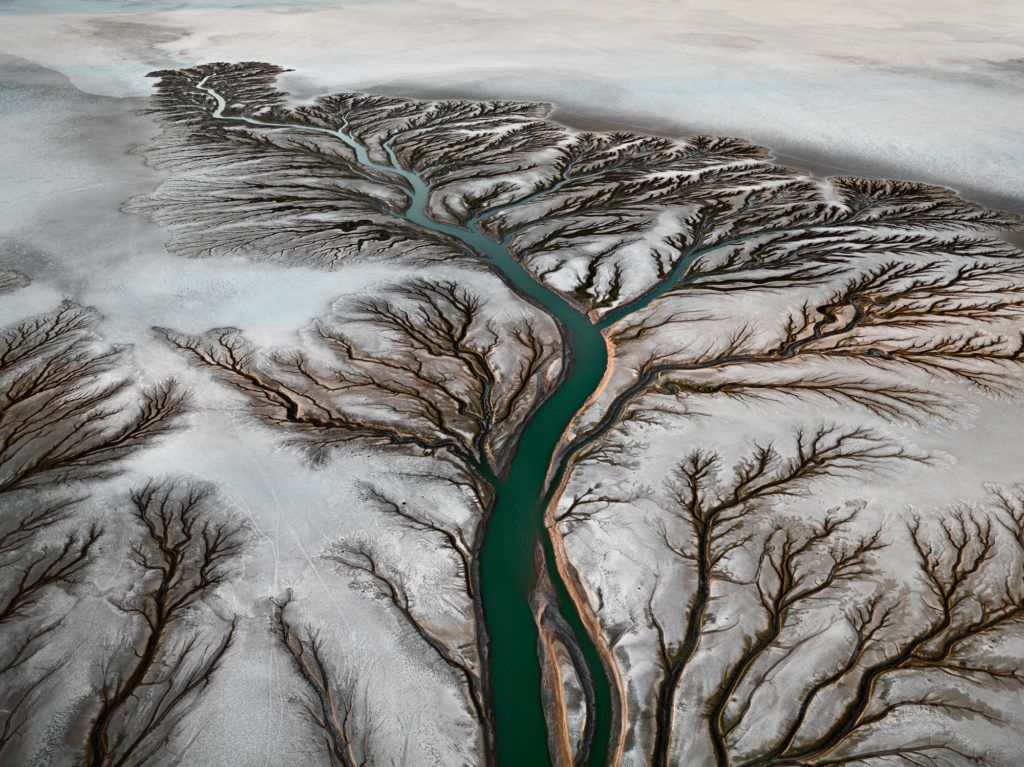 An image taken from above of a green river. 