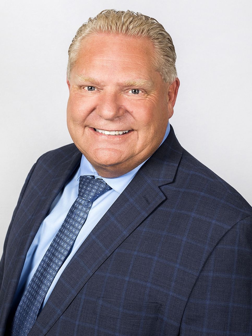 A man in a suit and tie is smiling for the camera.