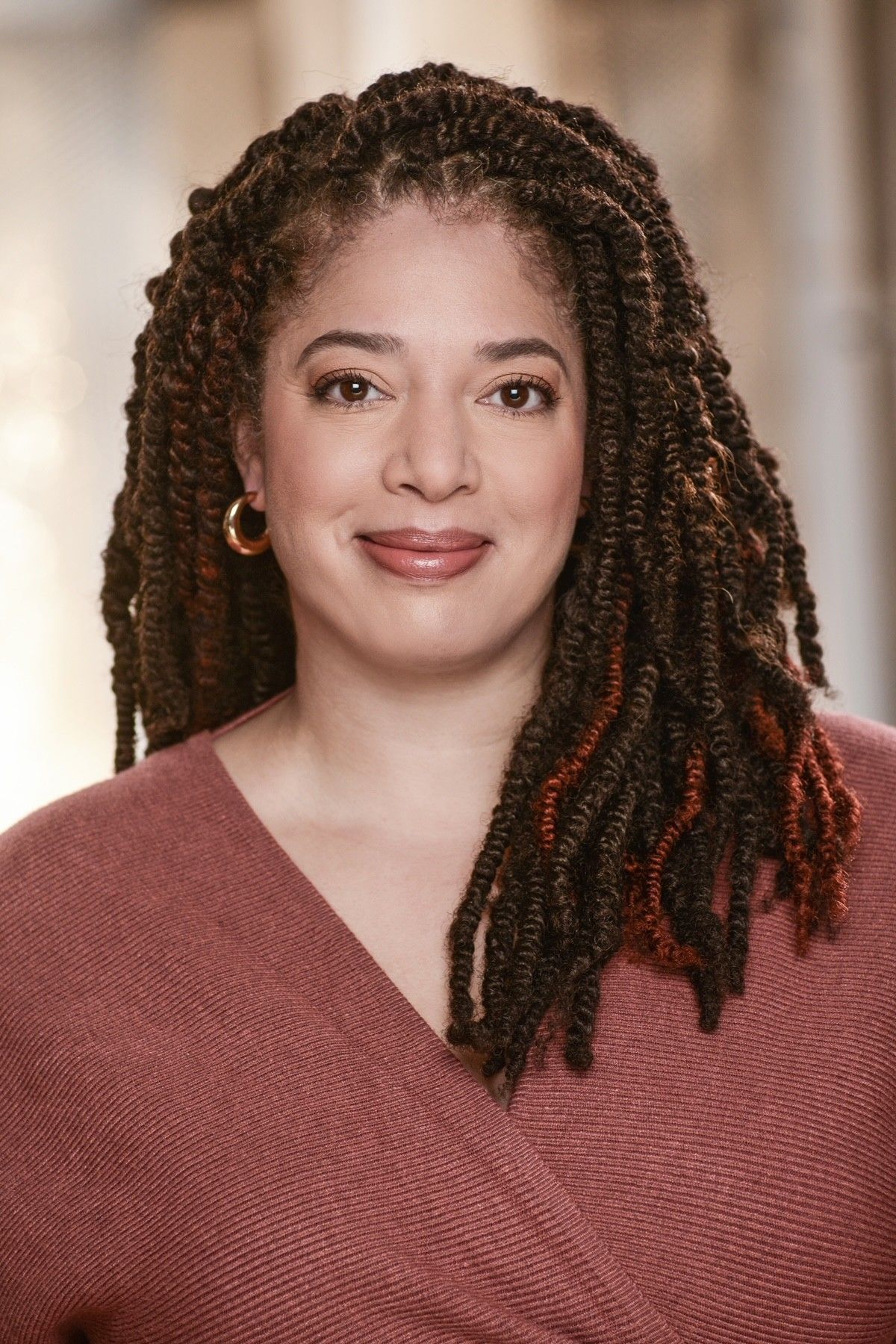 Image description: Smiling headshot of Rebecca Singh, a feminine presenting person of colour in her forties with coily brown hair.