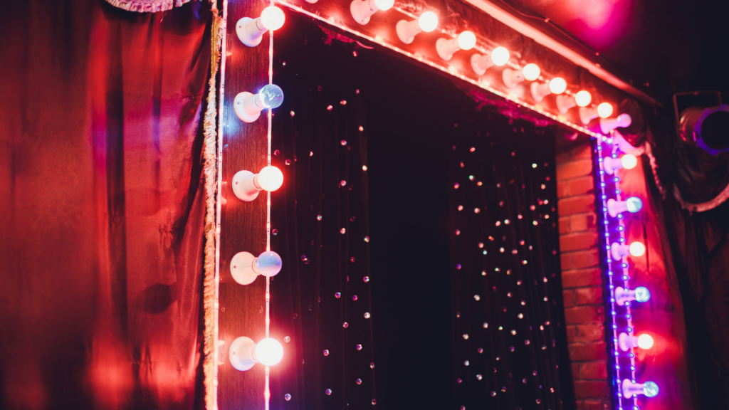 A stage with a lot of lights on it and a red curtain.