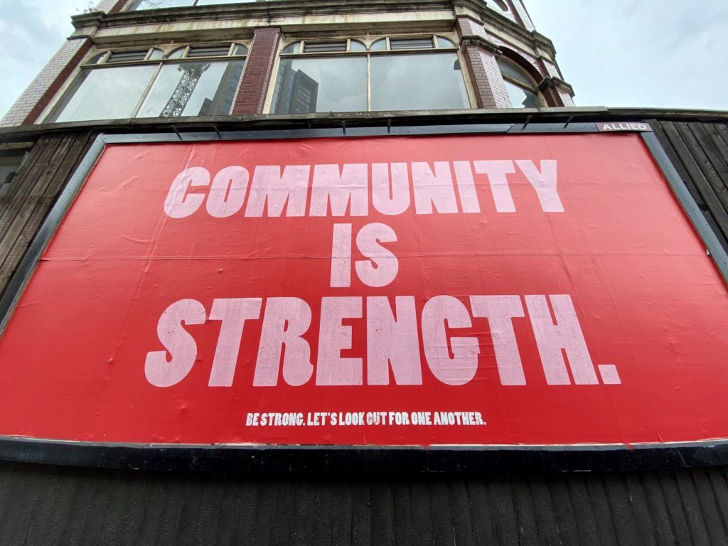 A photo of a large poster outside on a city building that says 