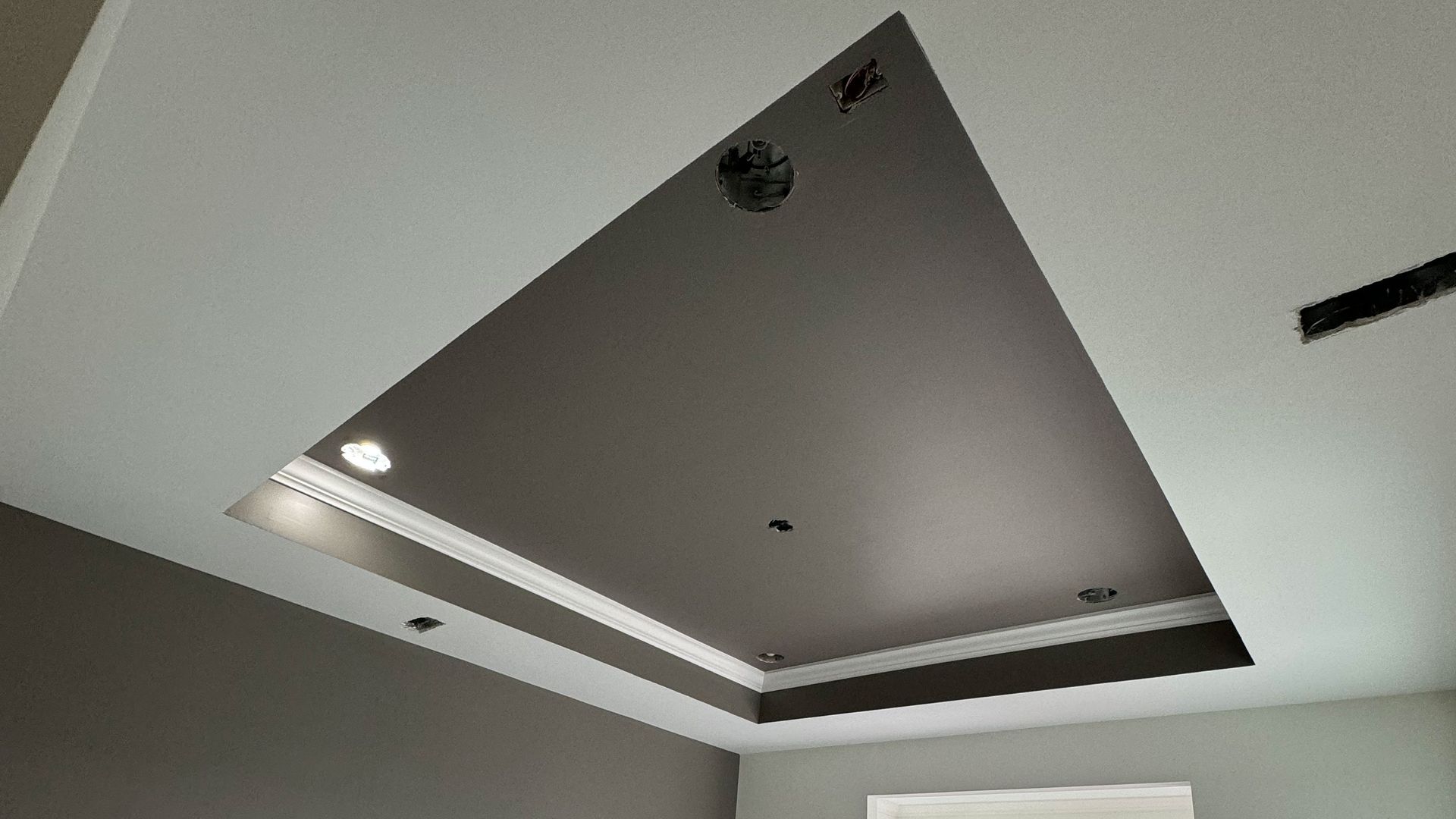 A ceiling with a triangle in the middle of it in a room.