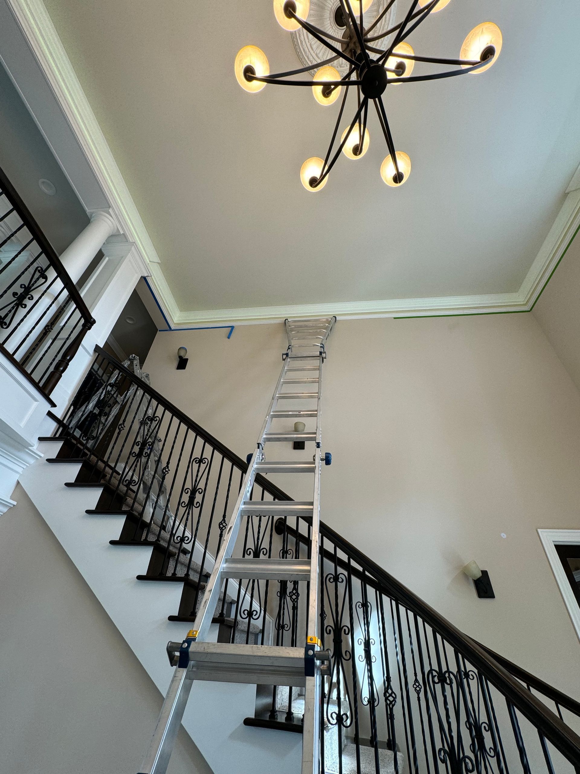 A ladder is hanging from the ceiling above a set of stairs