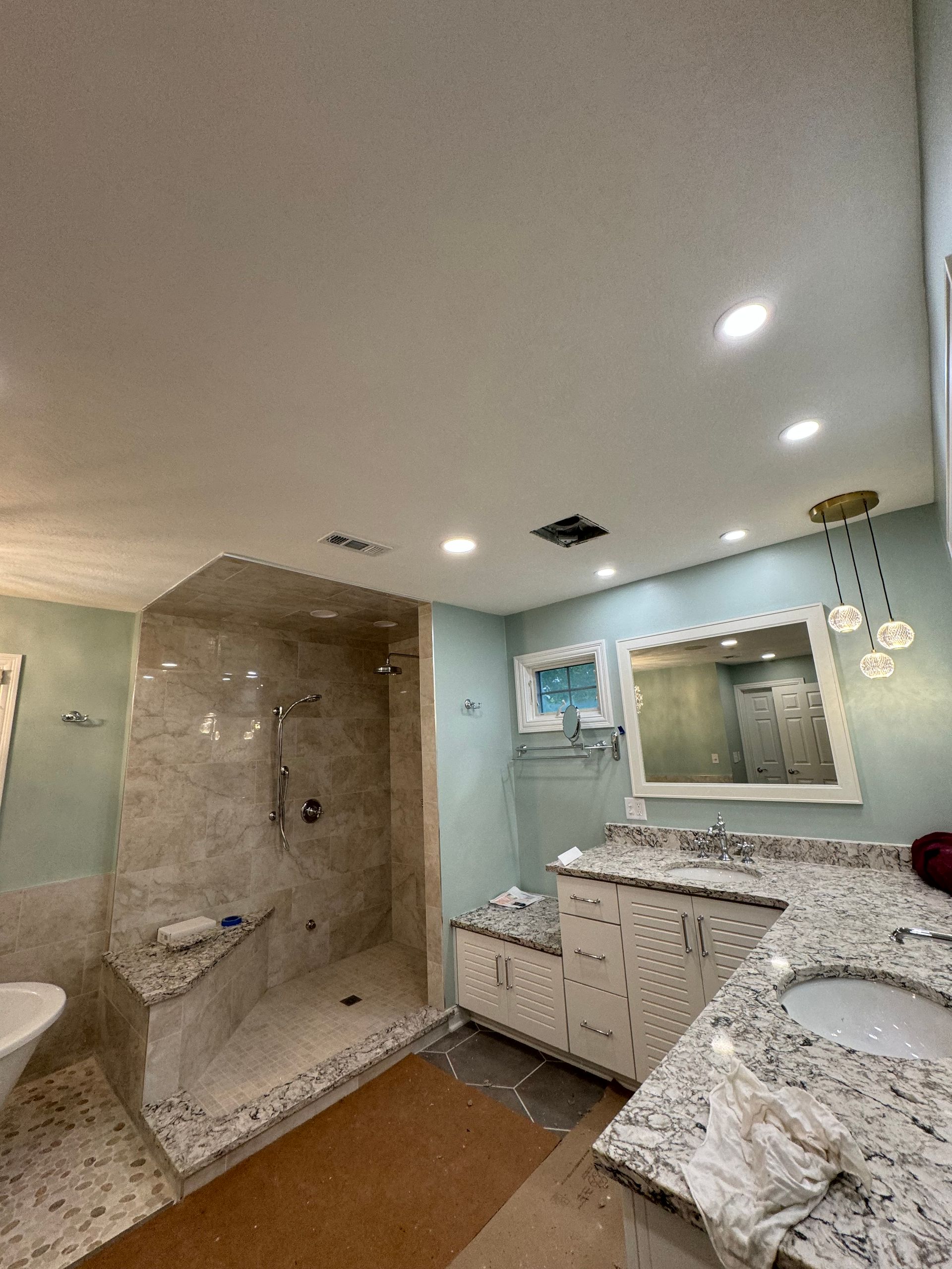 A bathroom with a walk in shower , sink , and mirror.