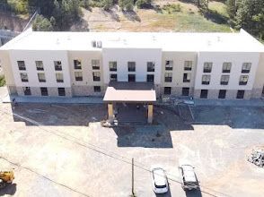 Construction site: Insulated concrete form walls being built; workers, bracing, and support structures visible.