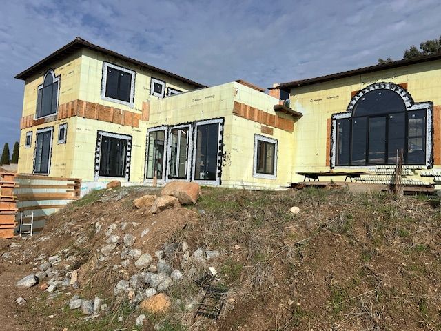 Construction site with ICF walls, supported by adjustable braces and scaffolding; exterior shot.