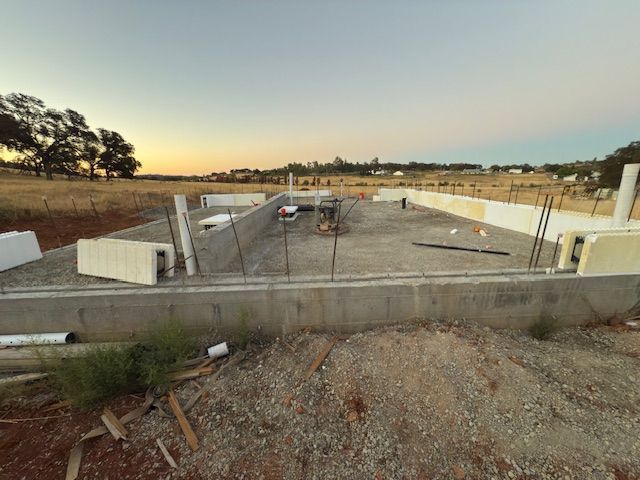 Reinforced steel grid (rebar) in a construction site, set in a rectangular formation against a dirt wall.