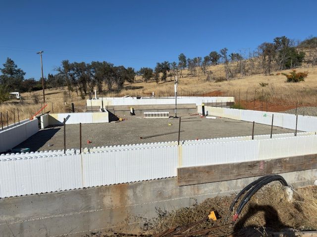 Construction site with ICF walls, supported by adjustable braces and scaffolding; exterior shot.