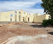 Construction site: Insulated concrete form walls being built; workers, bracing, and support structures visible.