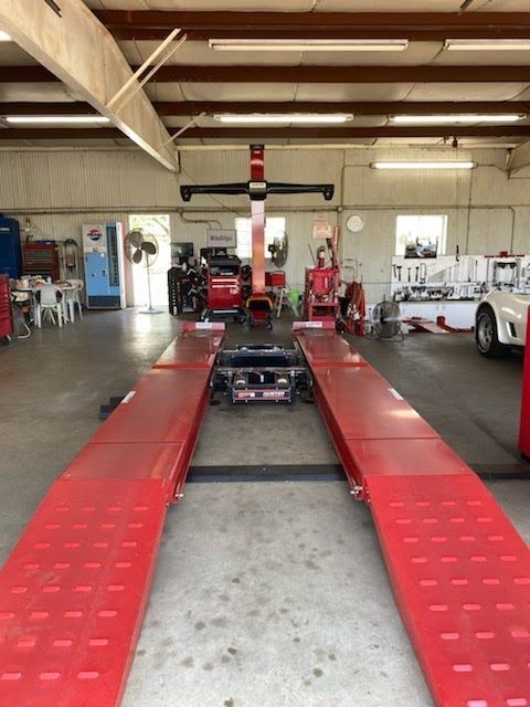 Red car lift in a car repair shop.