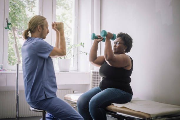 A male physical therapist is giving physical therapy to a female client.