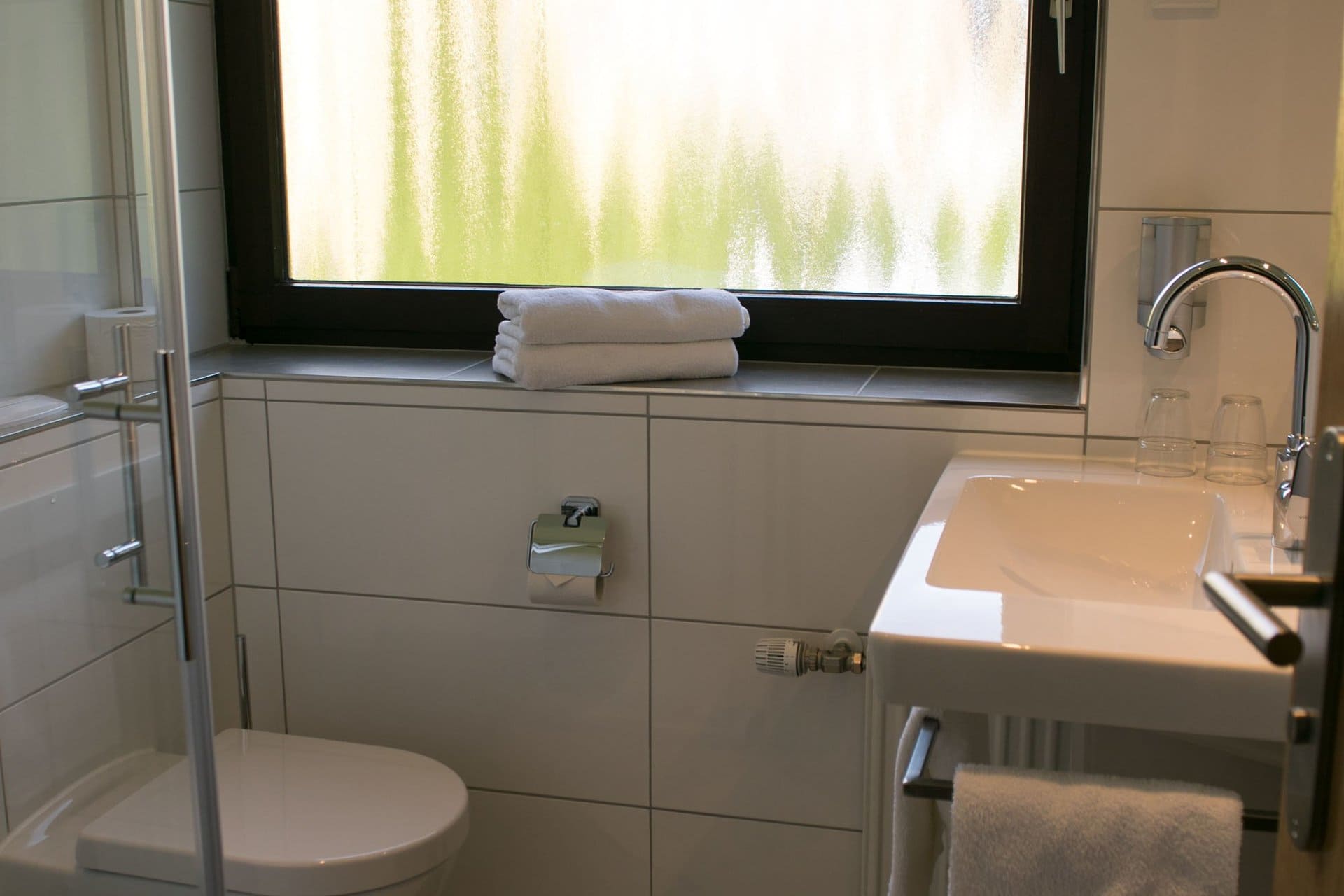 Ein Badezimmer mit Toilette, Waschbecken und Fenster