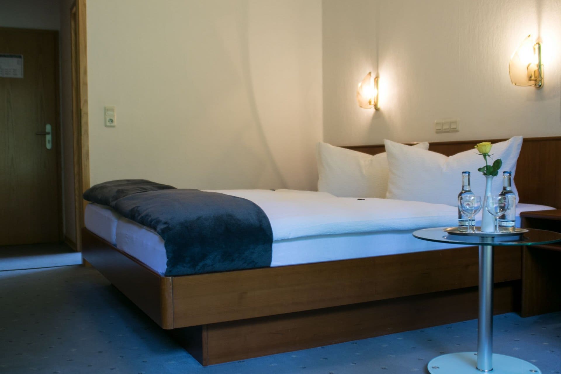 Ein Hotelzimmer mit einem Bett und einem Tisch mit Wasserflaschen darauf.