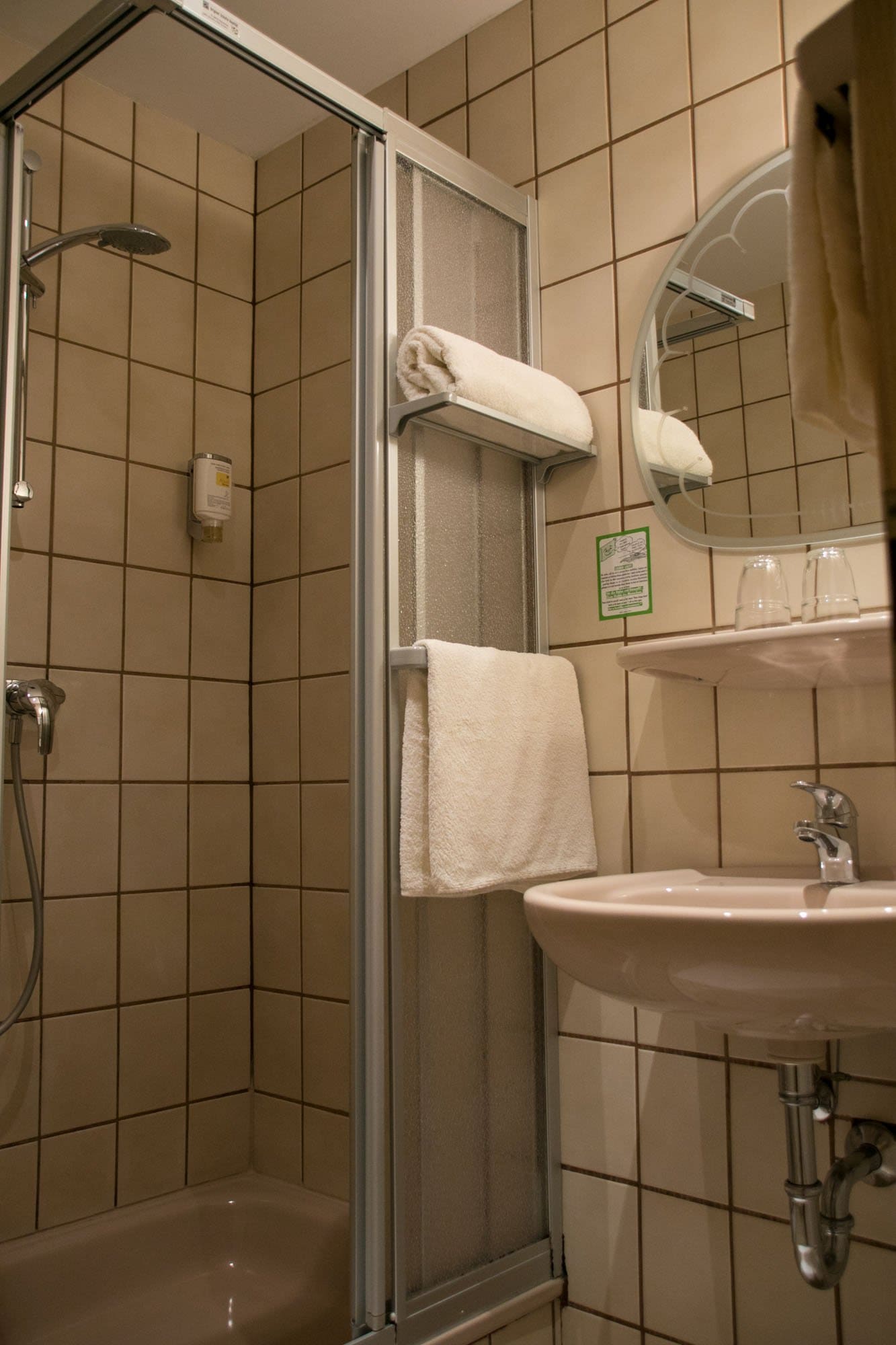 Ein Badezimmer mit Waschbecken, Dusche und Spiegel