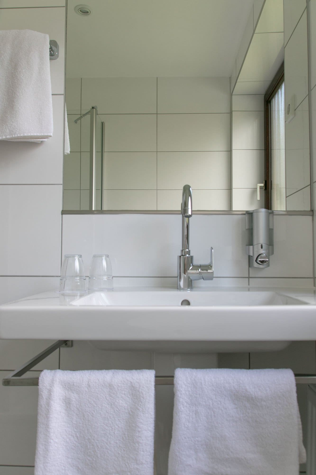 Ein Waschbecken im Badezimmer mit zwei weißen Handtüchern darunter