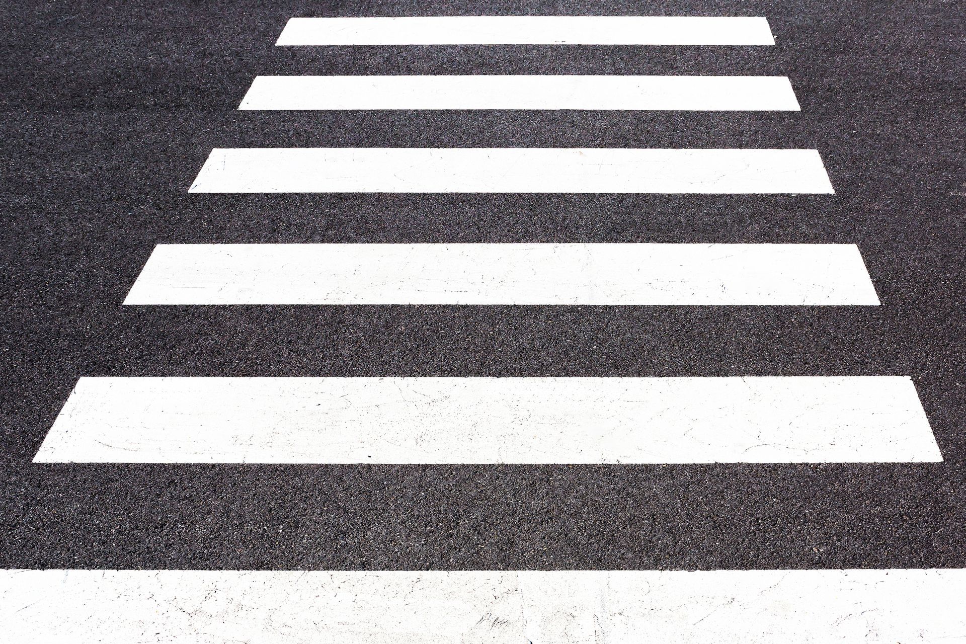 A horizontal row of line markings on an asphalted surface.