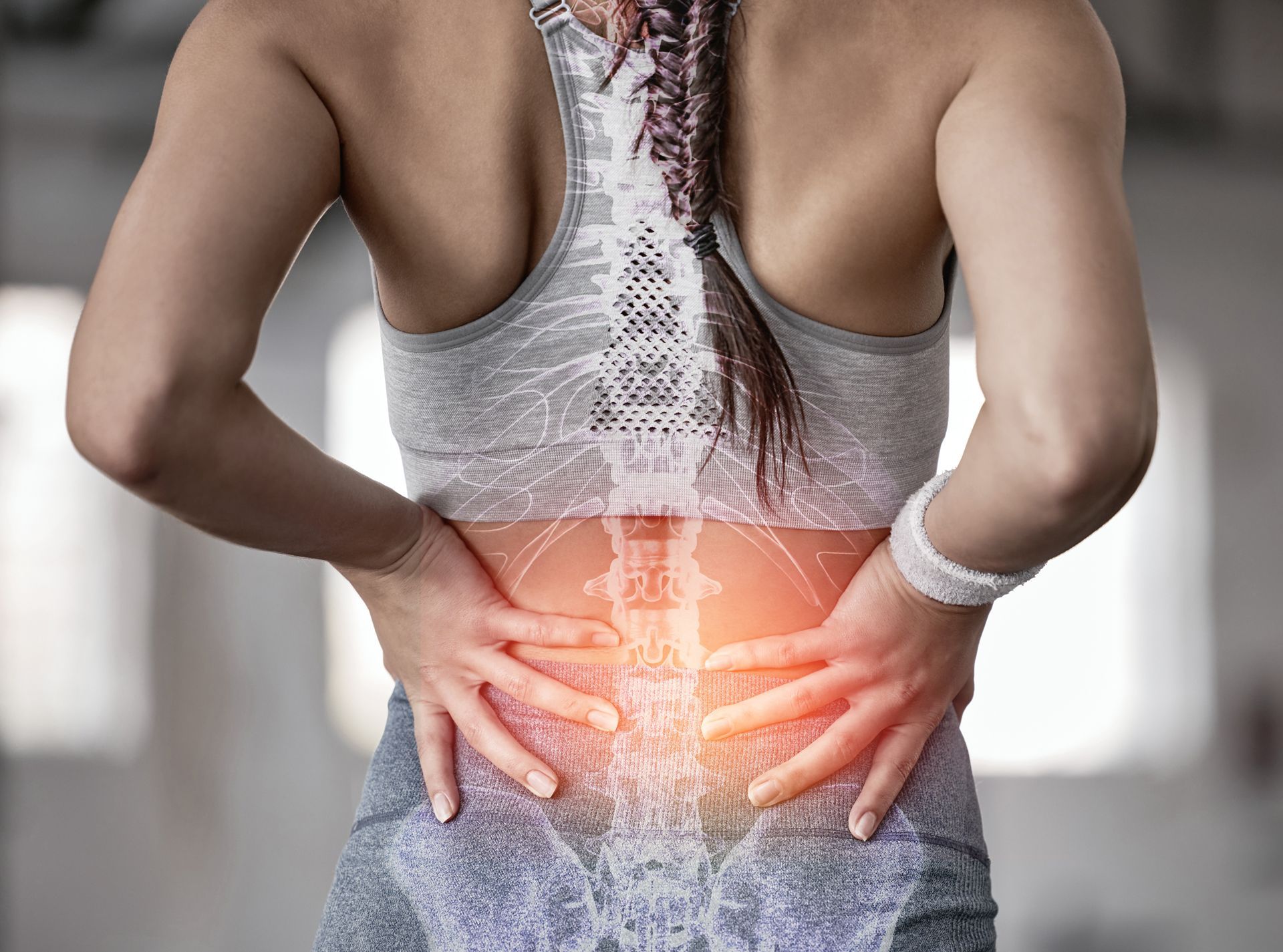 Woman with hands on lower back, showing pain with a highlighted spine illustration.