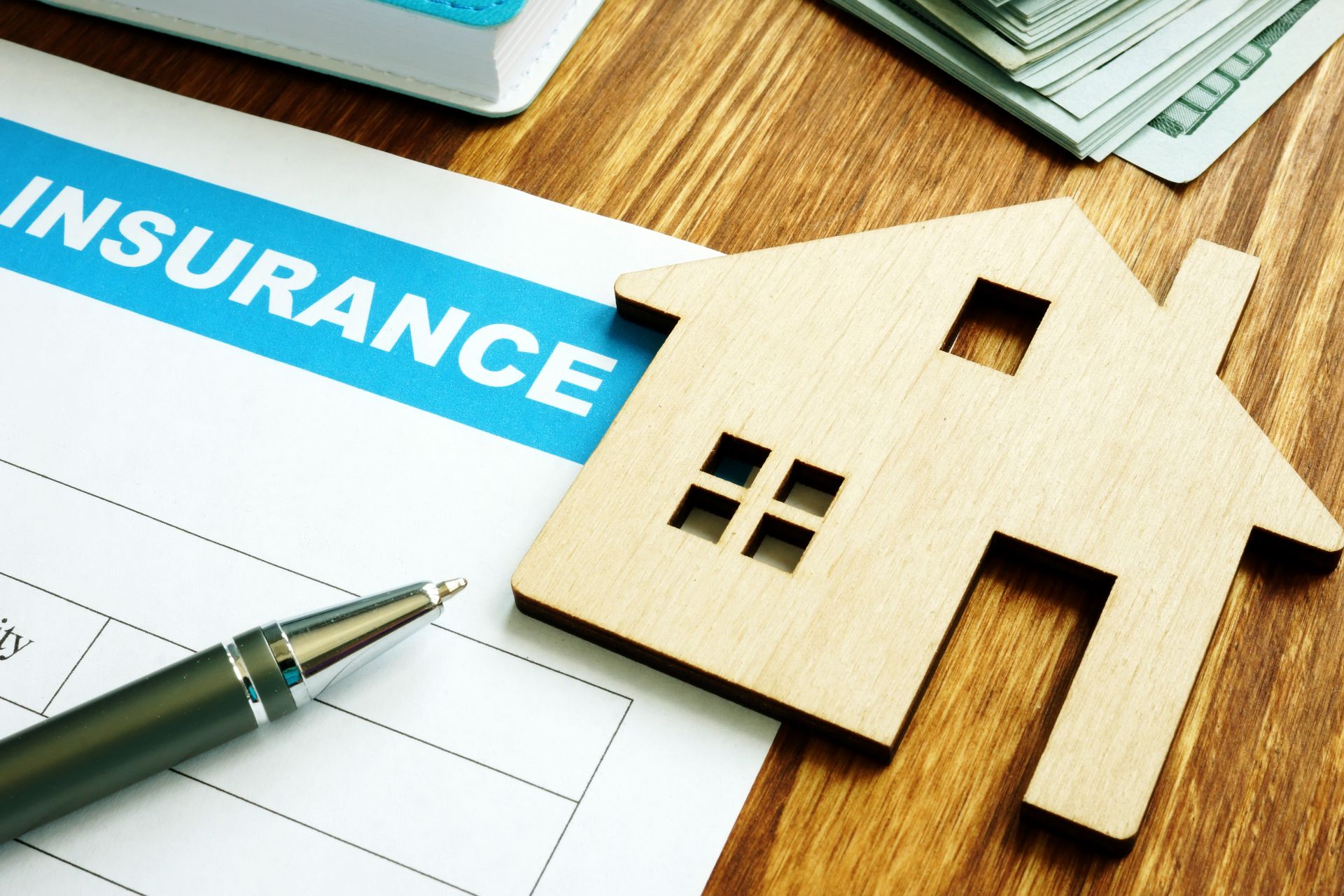 House insurance form and model of a wood house.