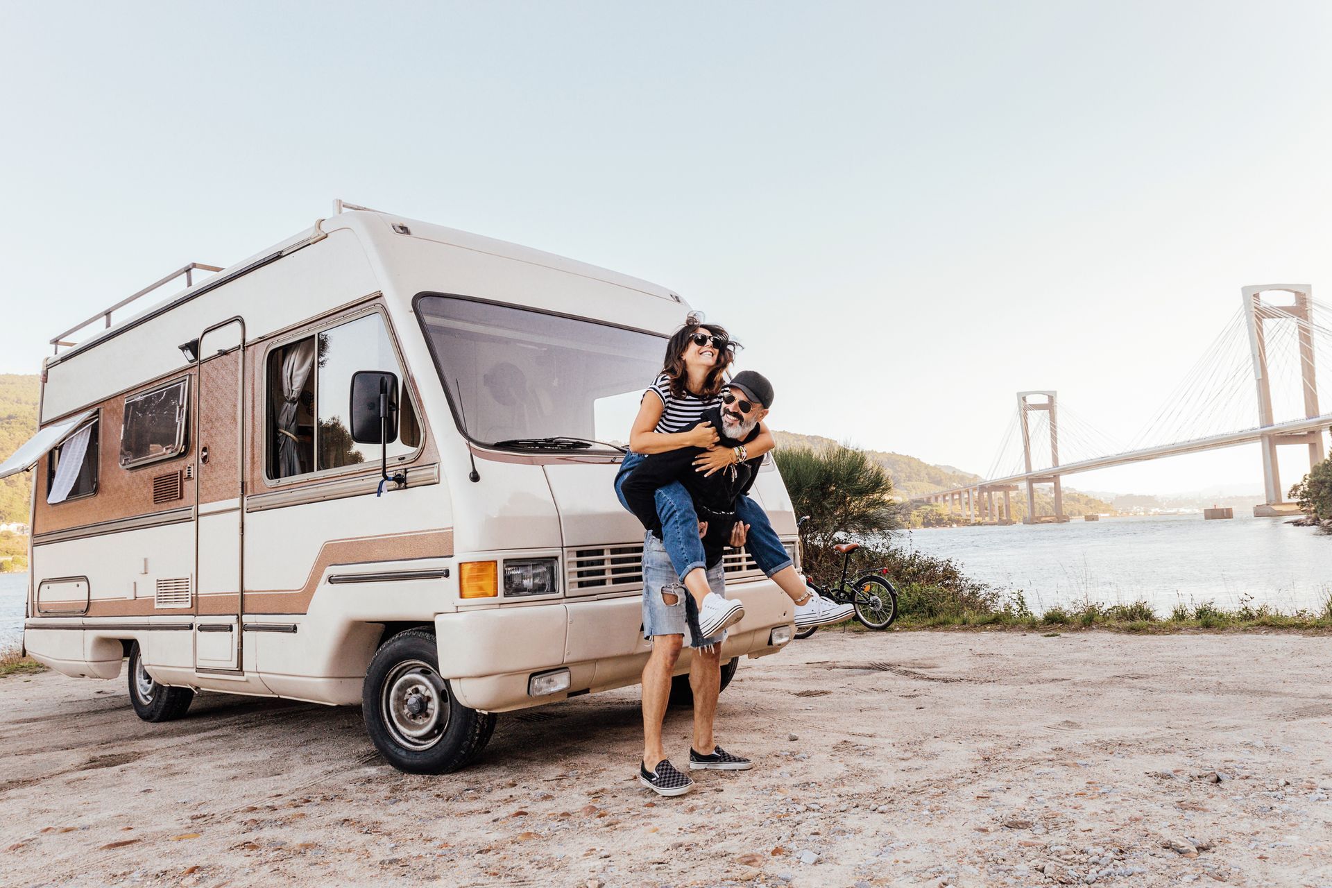 Couple having fun outside of a campervan.