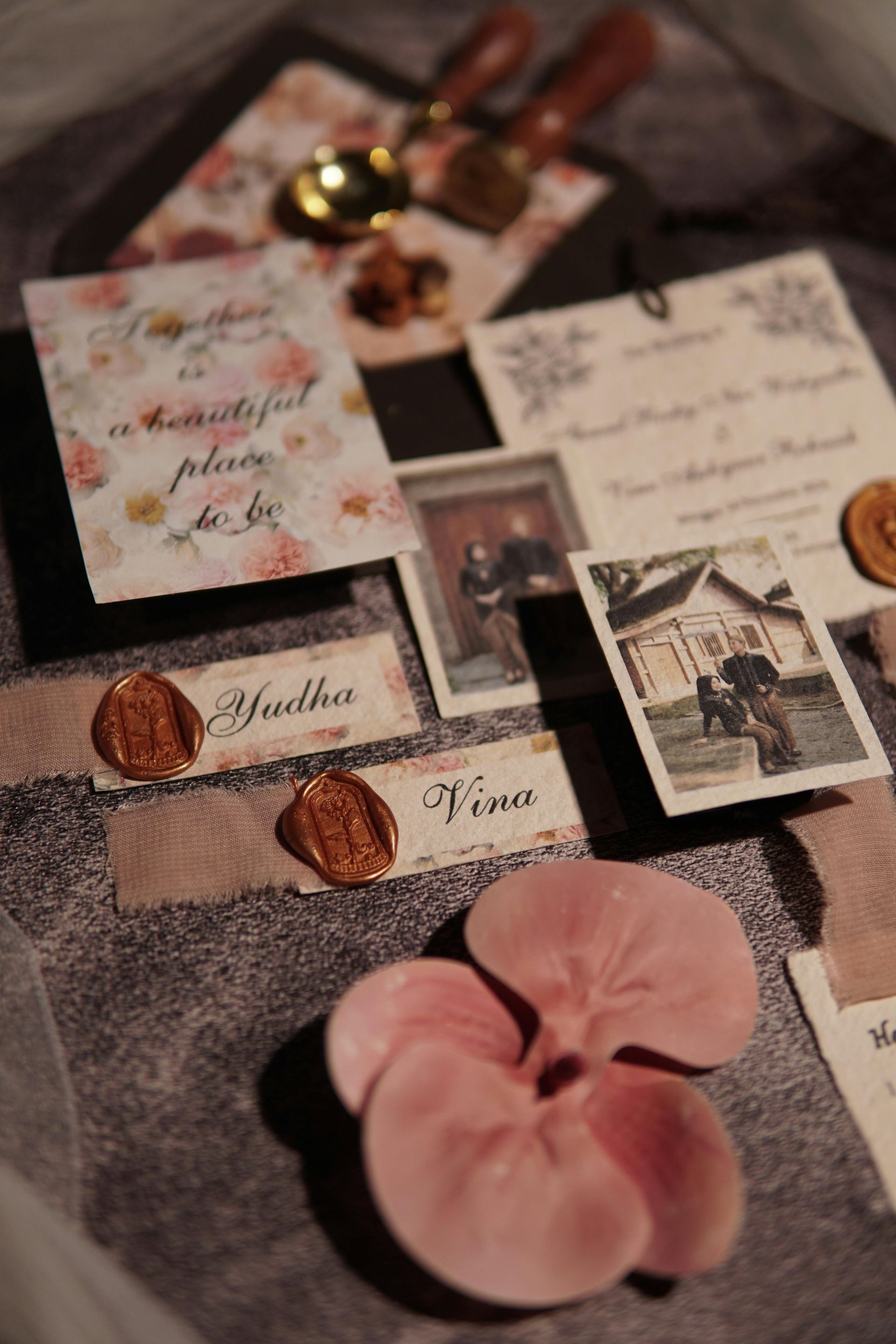 A close up of a tray with cards , wax seals , and flowers.