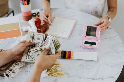 Two people are sitting at a table counting money.