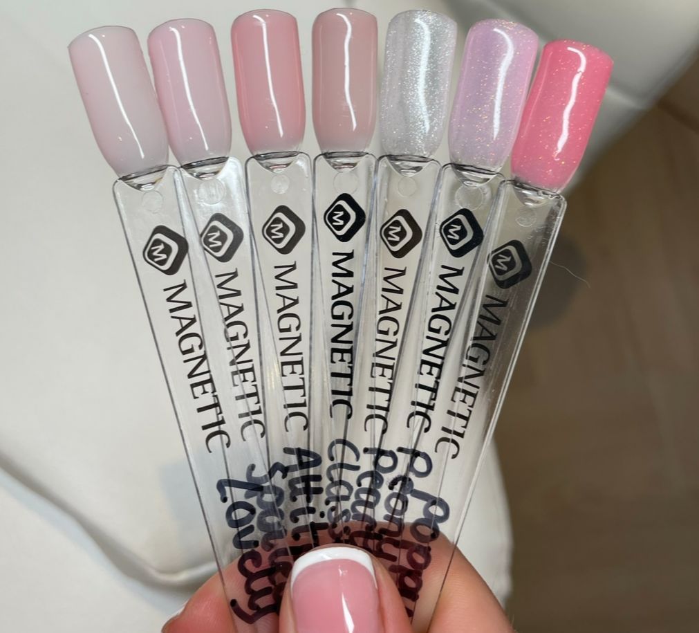 Een vrouw houdt een bosje magnetische nagellakmonsters vast