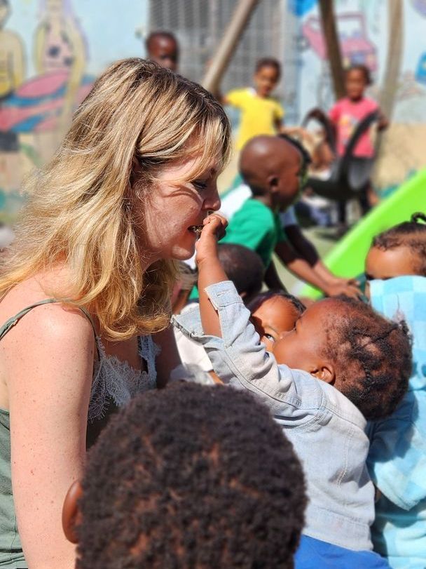 A young boy is drinking water from a faucet that says ' ethiopia ' on it