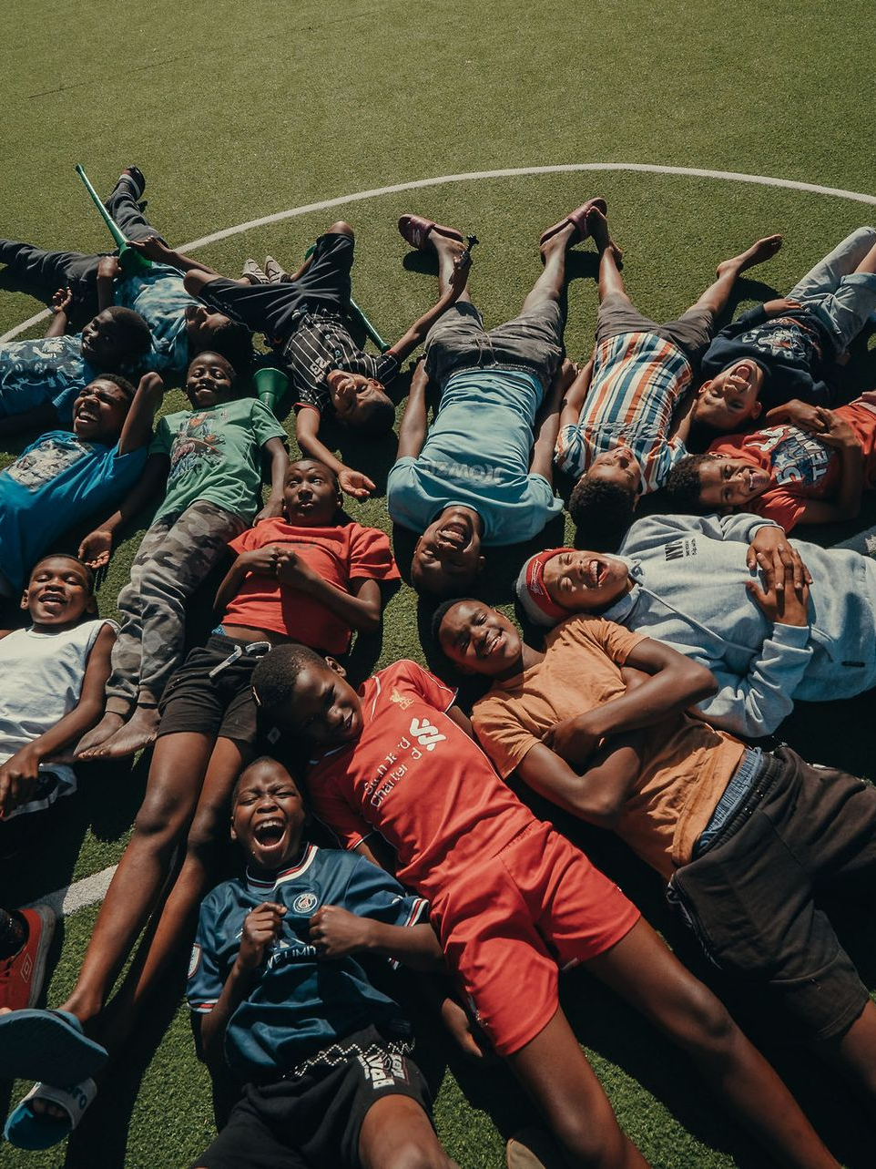 A young boy is drinking water from a faucet that says ' ethiopia ' on it