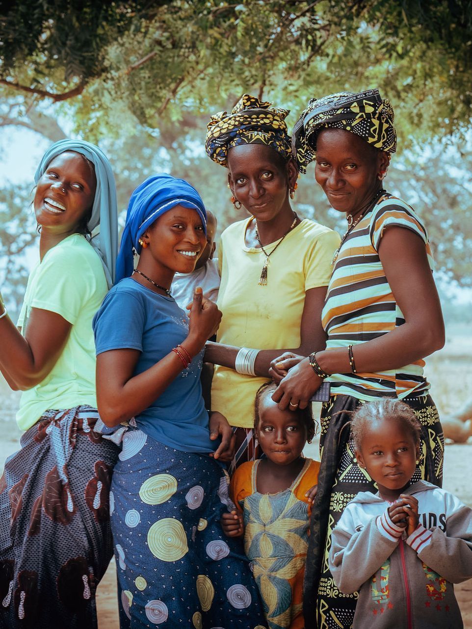 Two women are posing for a picture in front of a truck.