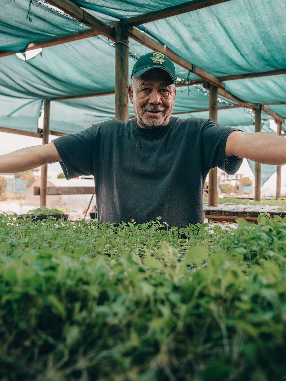 A woman is talking to a group of children sitting on the ground.