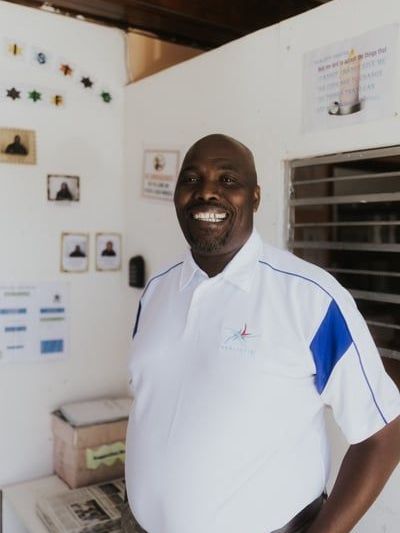 A young boy is drinking water from a faucet that says ' ethiopia ' on it