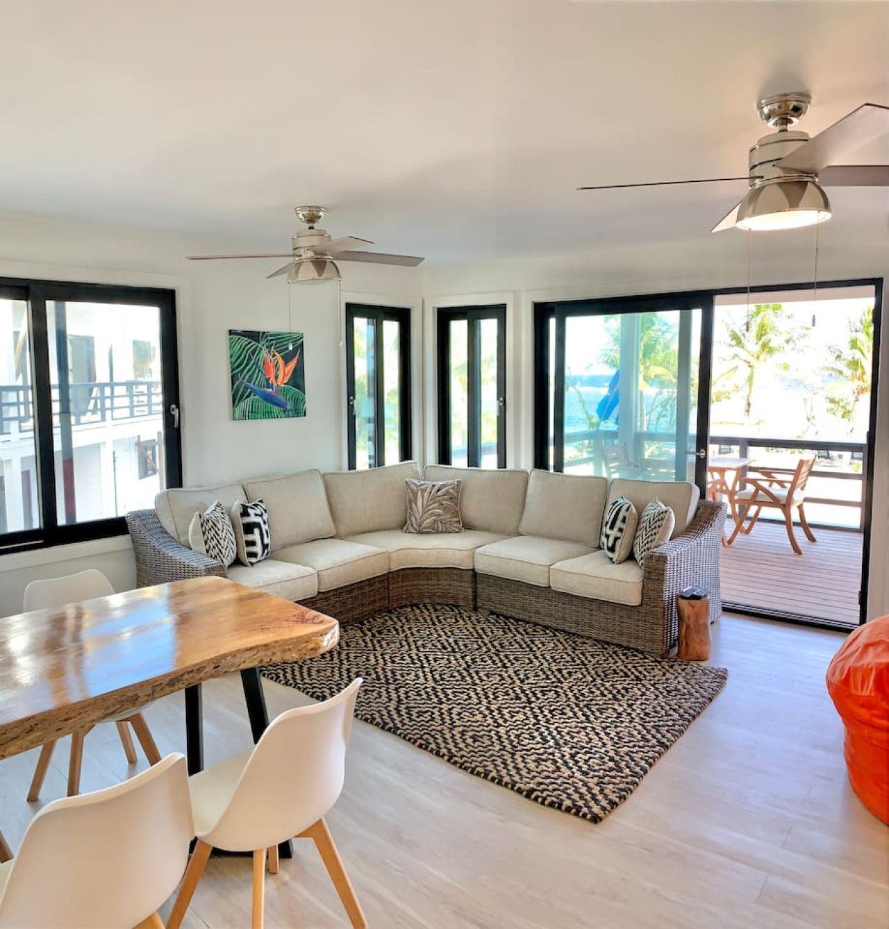 Living room with sectional sofa, rug, and dining table, with balcony access.
