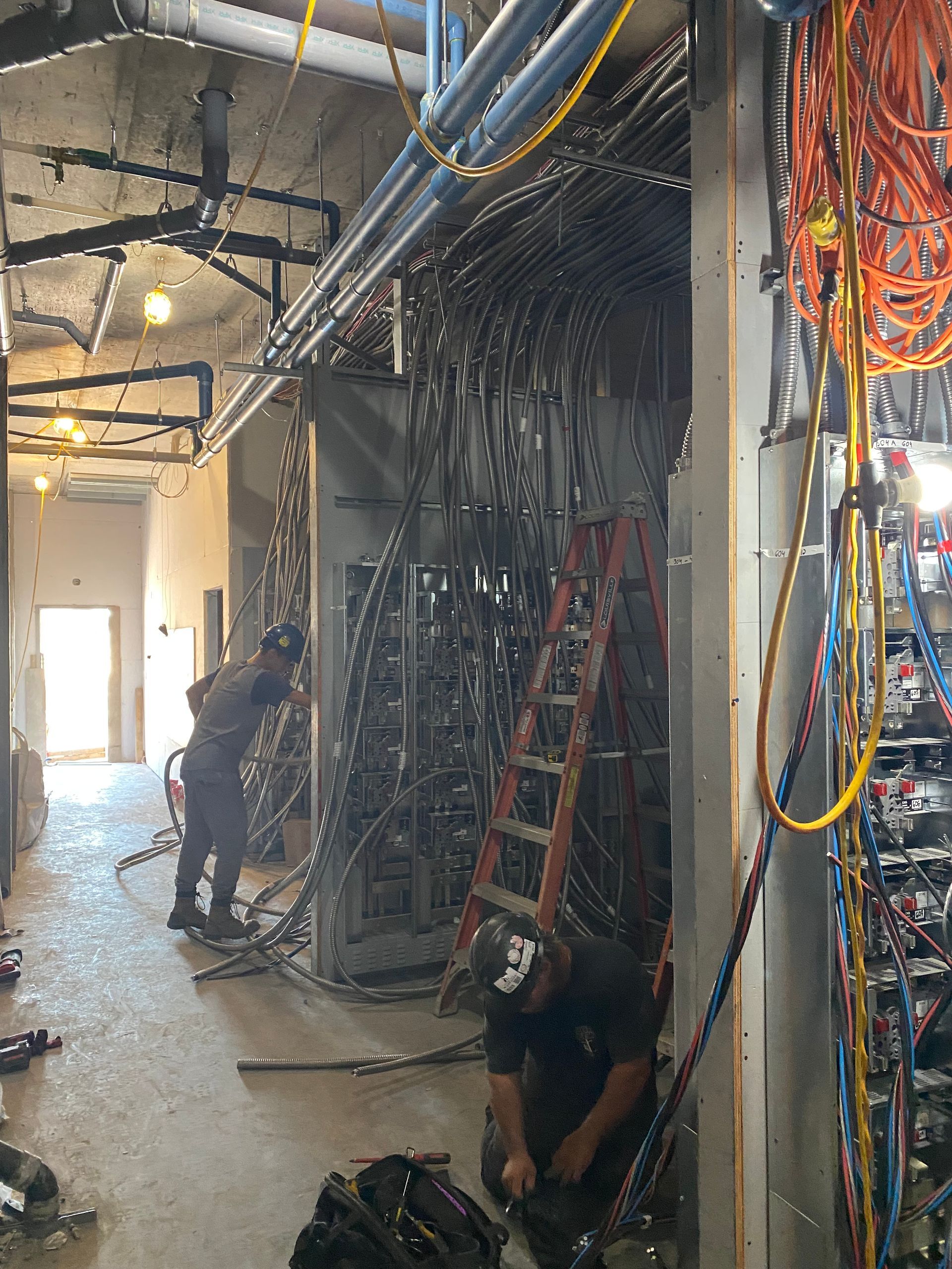 Un homme est à genoux dans une pièce avec une échelle.