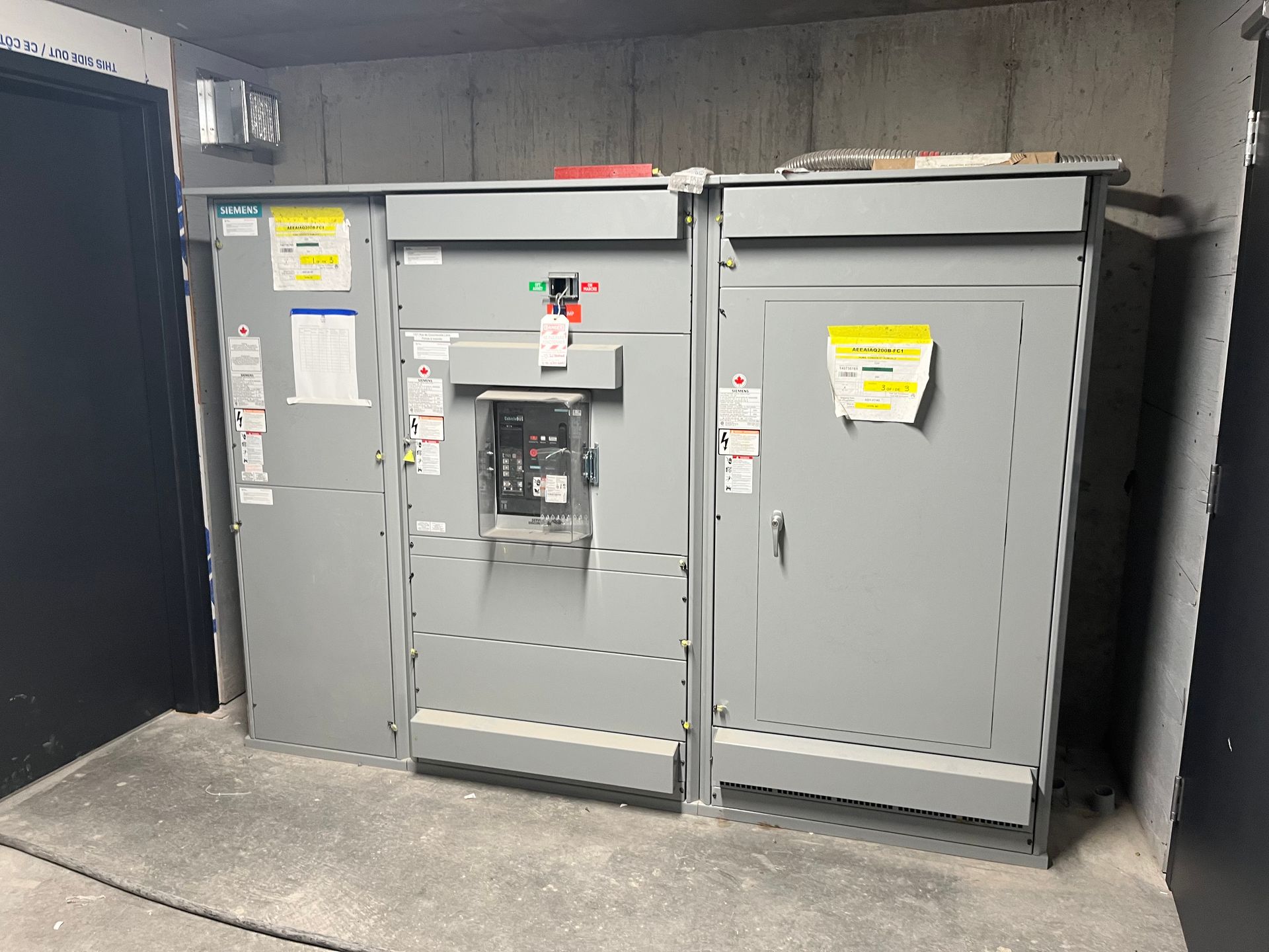 Deux boîtiers électriques sont placés l'un à côté de l'autre dans une pièce.