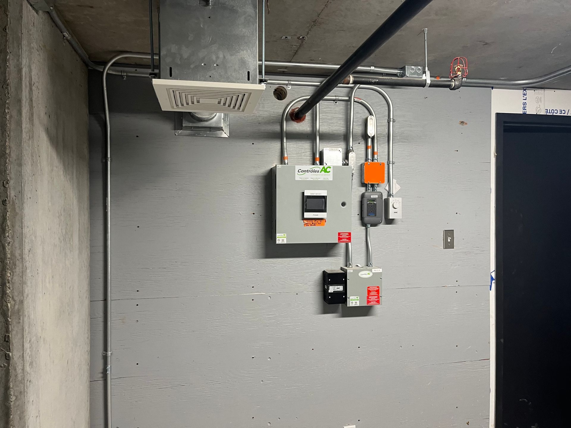 Un mur gris avec beaucoup de fils qui y pendent.