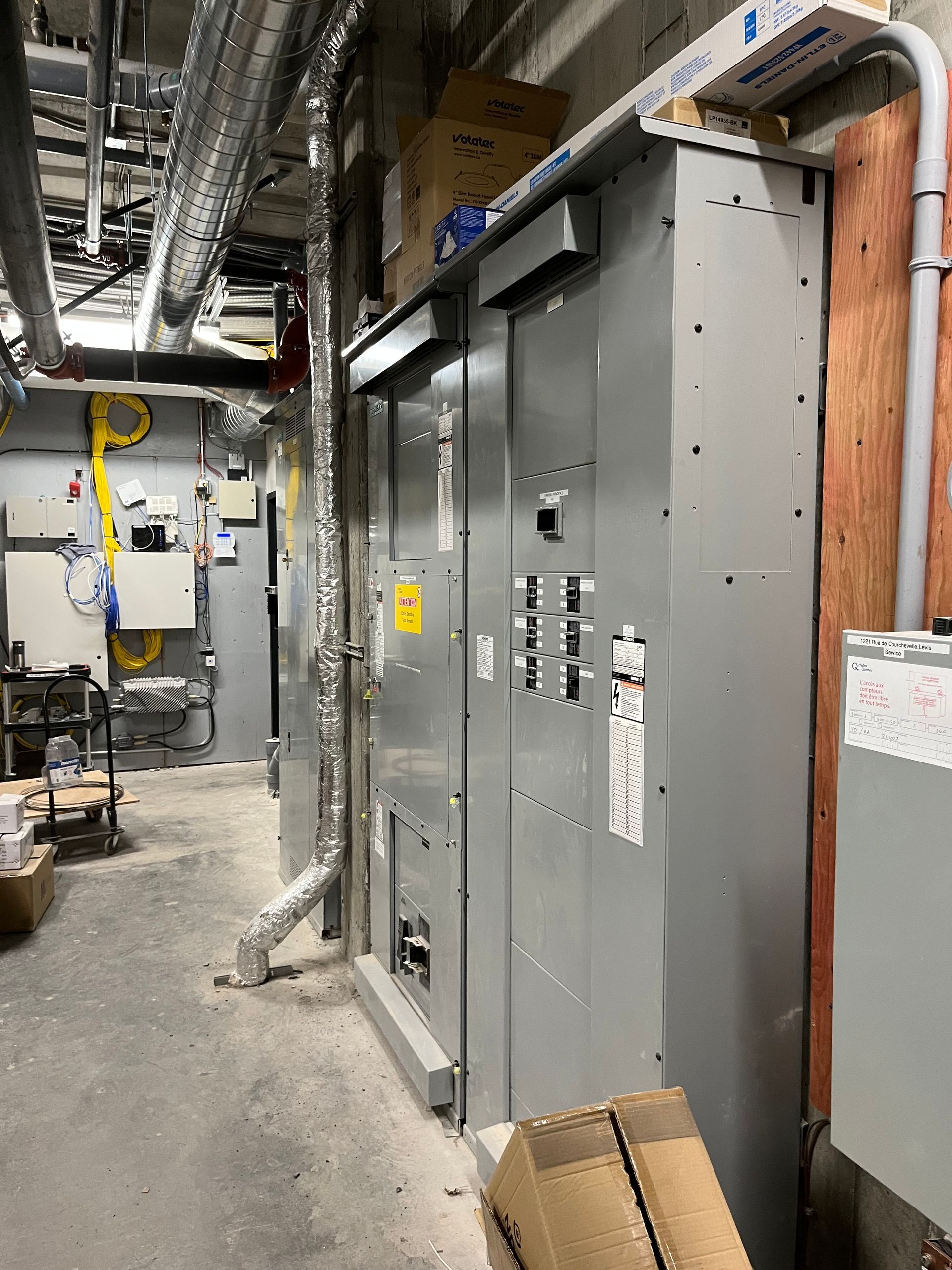 Une pièce avec beaucoup d'équipements électriques et de boîtes au sol