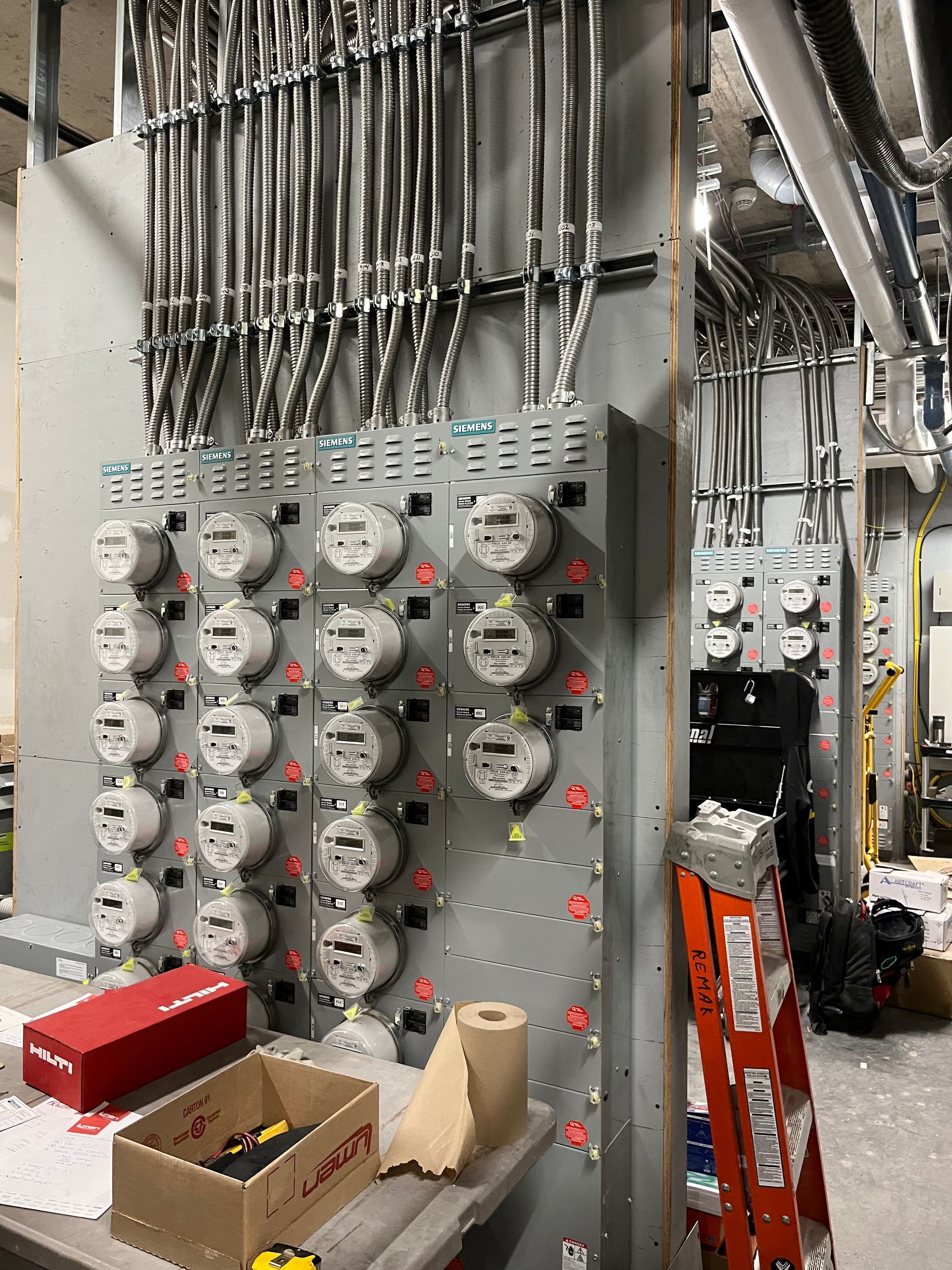 Une pièce avec beaucoup d'équipements électriques et une échelle.