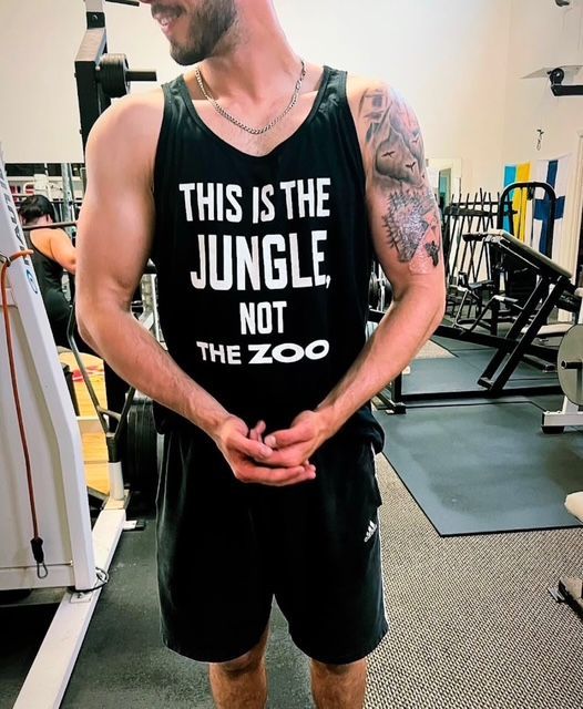 A man wearing a tank top that says this is the jungle not the zoo