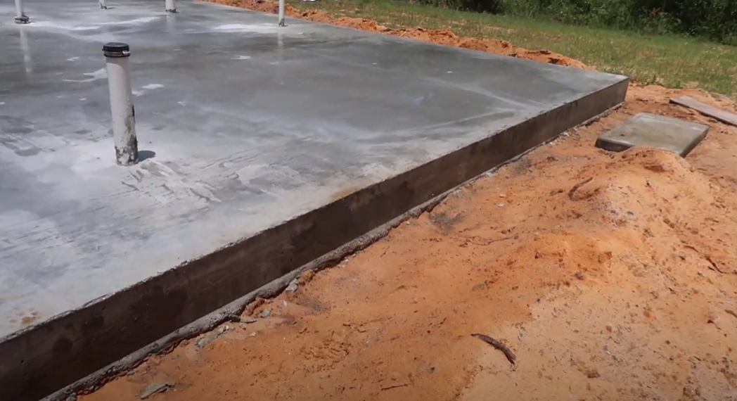 This is a picture of a concrete slab on grade in a backyard of a house.
