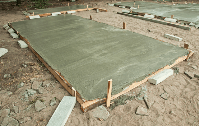 Picture of multiple freshly poured concrete slabs.  They are concrete slab on grade.