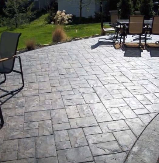 Picture of a stampcrete patio in the backyard of a house.