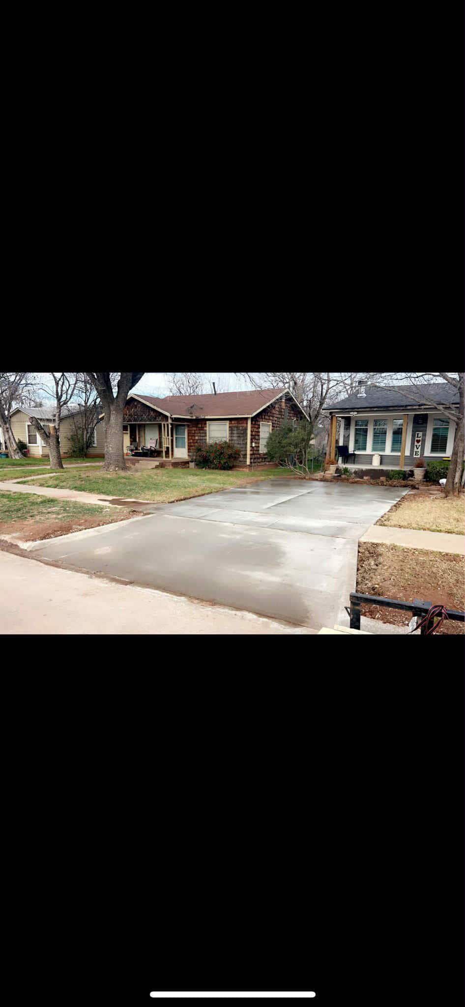 Houses with driveways on a suburban street. Gray, cloudy day.