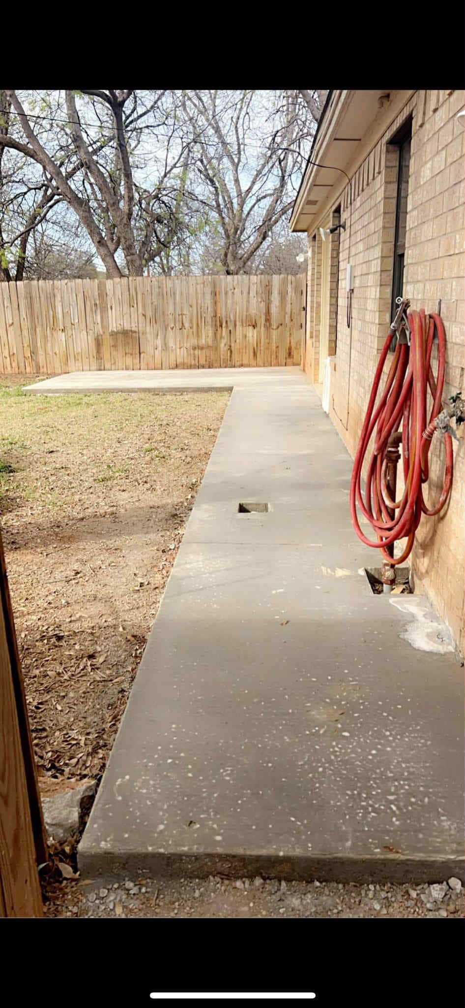 Silver car parked in a driveway in front of a house on a sunny day.