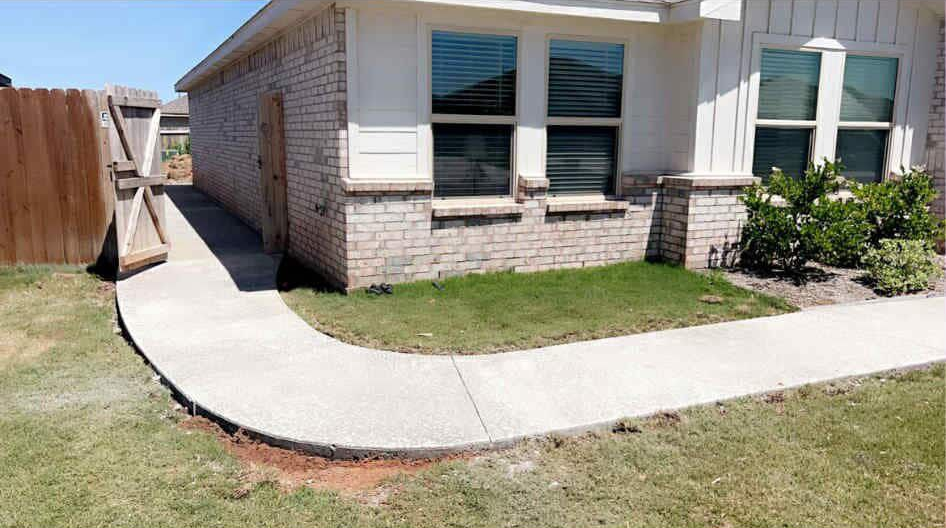 Two construction workers reviewing blueprints outside a building. One wears a yellow hard hat, the other a blue one.