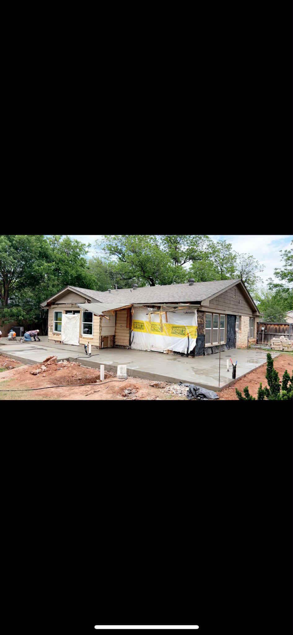 A house under construction with a concrete foundation and unfinished exterior walls.